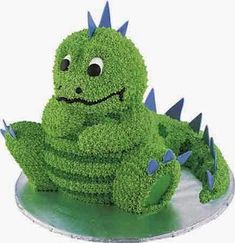 a cake shaped like a green dragon sitting on top of a plate