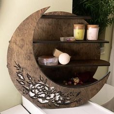 a wooden shelf with candles and soaps on it in the shape of a moon