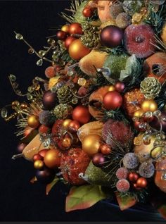 a christmas tree is decorated with ornaments and pineconis in shades of orange, gold and red