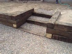 two wooden benches sitting on top of gravel