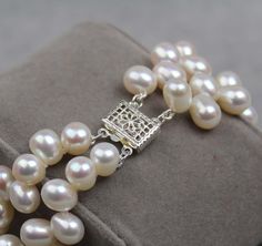 "Two strands of dancing freshwater pearls make a Tango!  This classic and feminine bracelet is a favorite for women with petite frames. The clasp is sterling silver rectangle filigree. Length including clasp is 7.5 inches but can be twisted to fit smaller wrist sizes.  For this reason, it makes a nice gift since will fit multiple wrist sizes. Pearl Type: Freshwater Cultured Pearl Pearl Shape: Tear drop, Top drilled (Dancing) Pearl Color: Natural White Pearl Luster: AAA Pearl Uniformity: Excellen Pearl White Bracelet With Sterling Silver Clasp As Gift, Timeless Silver Pearl Bracelets, Classic Adjustable Pearl Bracelet For Anniversary, Adjustable Classic Pearl Bracelet For Anniversary, Classic Silver Bracelet With Akoya Pearls, Classic Silver Bracelets With Akoya Pearl, Classic Silver Akoya Pearl Bracelet, Classic Silver Bracelet With Akoya Pearl, Classic Pearl Bracelet With Sterling Silver Clasp As Gift