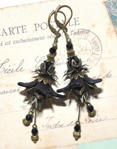 "Beautifully detailed earrings with frosted black lucite flowers, black faceted glass beads and bronze filigree bead caps and findings.  Black glass beads decorate the dangling stamens that sway and swing at the slightest movement. Nickel- and lead free antique bronze lever back brass earrings. These beauties measure approximately 70mm (2,8\") from the lower part of the hook. A romantic pair of vintage style earrings full of whimsical charm and timeless beauty! If you have any questions just convo me and I will get back to you as soon as possible. Thanks for looking // Mari" Black Bohemian Dangle Flower Earrings, Bohemian Black Dangle Flower Earrings, Bohemian Black Flower Earrings For Gift, Artistic Black Dangle Earrings, Artistic Black Drop Earrings, Artistic Black Dangle Jewelry, Artistic Black Jewelry With Matching Earrings, Unique Black Earrings For Evening, Handmade Victorian Black Earrings