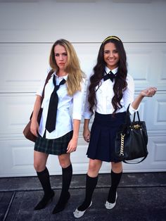 two girls dressed in school uniforms posing for the camera