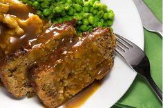 meatloaf with gravy, peas and mashed potatoes on a plate