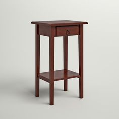 a small wooden table with one drawer on the top and two shelves below it, against a white background