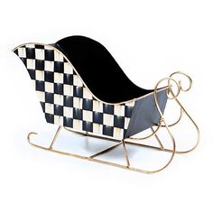 a black and white checkered sleigh with gold accents on the sides, sitting in front of a white background