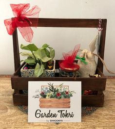 a wooden box filled with potted plants on top of a table next to a sign