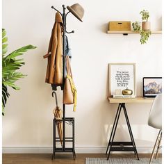 a coat rack with hats and umbrellas on it in front of a white wall