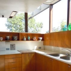 an empty kitchen with wooden cabinets and white counter tops is seen in this image from the inside