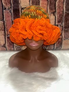 a mannequin head with an orange knitted hat on it's head