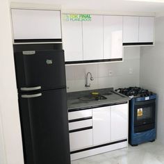 a black refrigerator freezer sitting next to a stove top oven