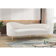 a white couch sitting on top of a wooden floor next to a plant in a living room