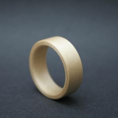 a gold ring on a black surface with no one in the photo looking at it