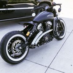 a black and white motorcycle parked next to a car