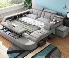 a living room with a couch, desk and laptop on top of the sofa bed