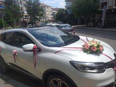 a car decorated with flowers and ribbons on the street