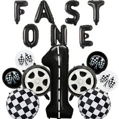 some black and white balloons are in the shape of checkered tires with words that say,'fast one '