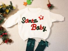 Introducing our personalized baby sweater! Made of high-quality cotton, this cute and practical sweater is the perfect gift. Our unique design keeps your little one comfortable and stylish. It is suitable for any occasion and is a warm hug for your baby. Material: Cotton, Yarn Customization Options: Please provide the yarn color, the slogan "Santa baby" is fixed in red and green color as shown in the picture. If you want some Christmas accessories, please contact me. Processing Time: Within one Embroidery Name Sweater, Customized Baby Gifts, Baby Name Sweater, Newborn Sweater, Knit Baby Sweater, Embroidered Sweaters, Name Sweater, Sweater Embroidery, Cadeau Baby Shower