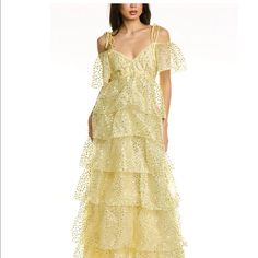 Cinq Sept Doris Organza Gown With Tie Straps And Cold Shoulder Sleeve Details. Features Tiered Ruffles And Sequin Accents. Details Hidden Zipper On Back Fabric: Sequin Organza Maxi Tie Strap Detail Cold Shoulder Sleeve Content And Care 100% Polyester Dry Clean Imported Festive Tiered Wedding Dress, Yellow Lace Maxi Dress For Party, Summer Wedding Gown In Gold, Gold Wedding Gown For Summer, Gold Summer Wedding Gown, Tiered Gown For Gala, Elegant Yellow Tiered Maxi Dress, Elegant Yellow Lace Maxi Dress, Glamorous Tiered Evening Dress For Wedding