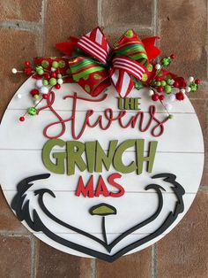 a sign that says the stevens grinch mas is hanging on a brick wall in front of a door