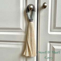 a door handle with a tassel hanging from it's side on a white door