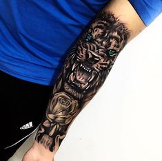 a man's arm with a tiger and roses tattoo on the left side of his arm