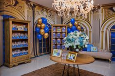 a living room decorated with blue and gold balloons, bookshelves, and pictures