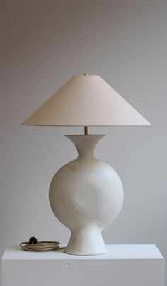 a white lamp sitting on top of a table