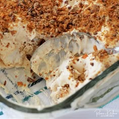 an ice cream dessert in a glass dish with spoons and crumbs on top