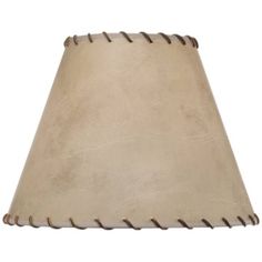 a lamp shade that is beige and has brown stitching on the bottom of it