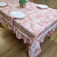 the table is covered with pink flowers and lace