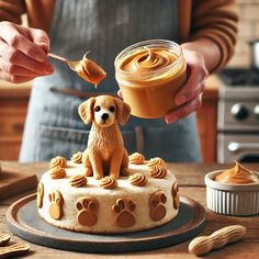 a person holding a spoon over a cake with icing and dog paw prints on it