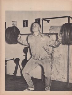 an old photo of a man lifting a barbell