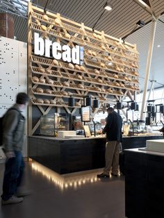 people are walking around in front of a bread display at a store with the word bread written on it