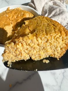 a piece of cake sitting on top of a white plate next to a bowl filled with food