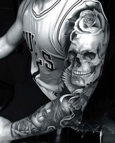 black and white photograph of a man with tattoos on his arm holding a basketball jersey