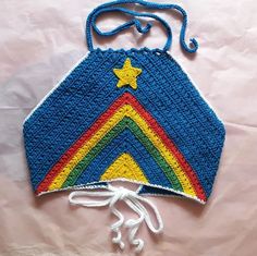 a crocheted bag with a star and rainbow design on the front, hanging from a string