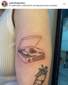 a woman's arm with a tattoo of a record player and a carrot on it