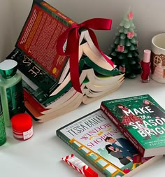 several books are sitting on a table with christmas decorations