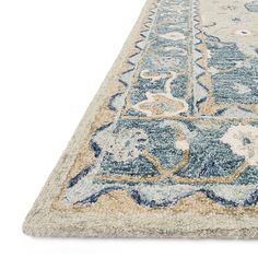 a blue and beige area rug with an ornate design on the bottom, in front of a white background