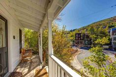 a porch with rocking chairs on it and mountains in the background