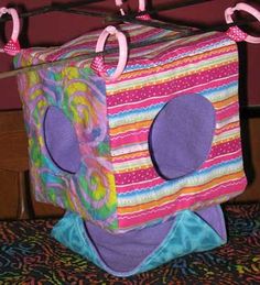 a stuffed animal sitting on top of a bed under a clothes line with two hooks