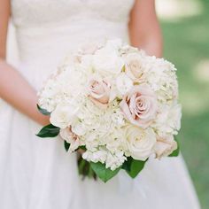 a bride holding a bouquet of white and pink flowers