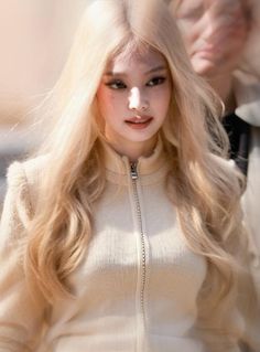 a woman with long blonde hair walking down the street