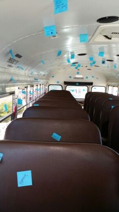 the inside of a bus with blue sticky notes on its ceiling and seats in it