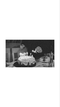 a black and white photo of a birthday cake with lit candles