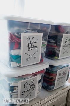 two plastic bins with labels on them are stacked next to each other in front of a window