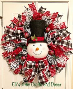 a christmas wreath with a snowman wearing a top hat and bow tie on the front door