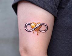 a woman's arm with a tattoo on it that has an orange heart in the middle