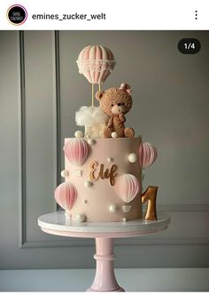 a three tiered cake decorated with balloons and teddy bears